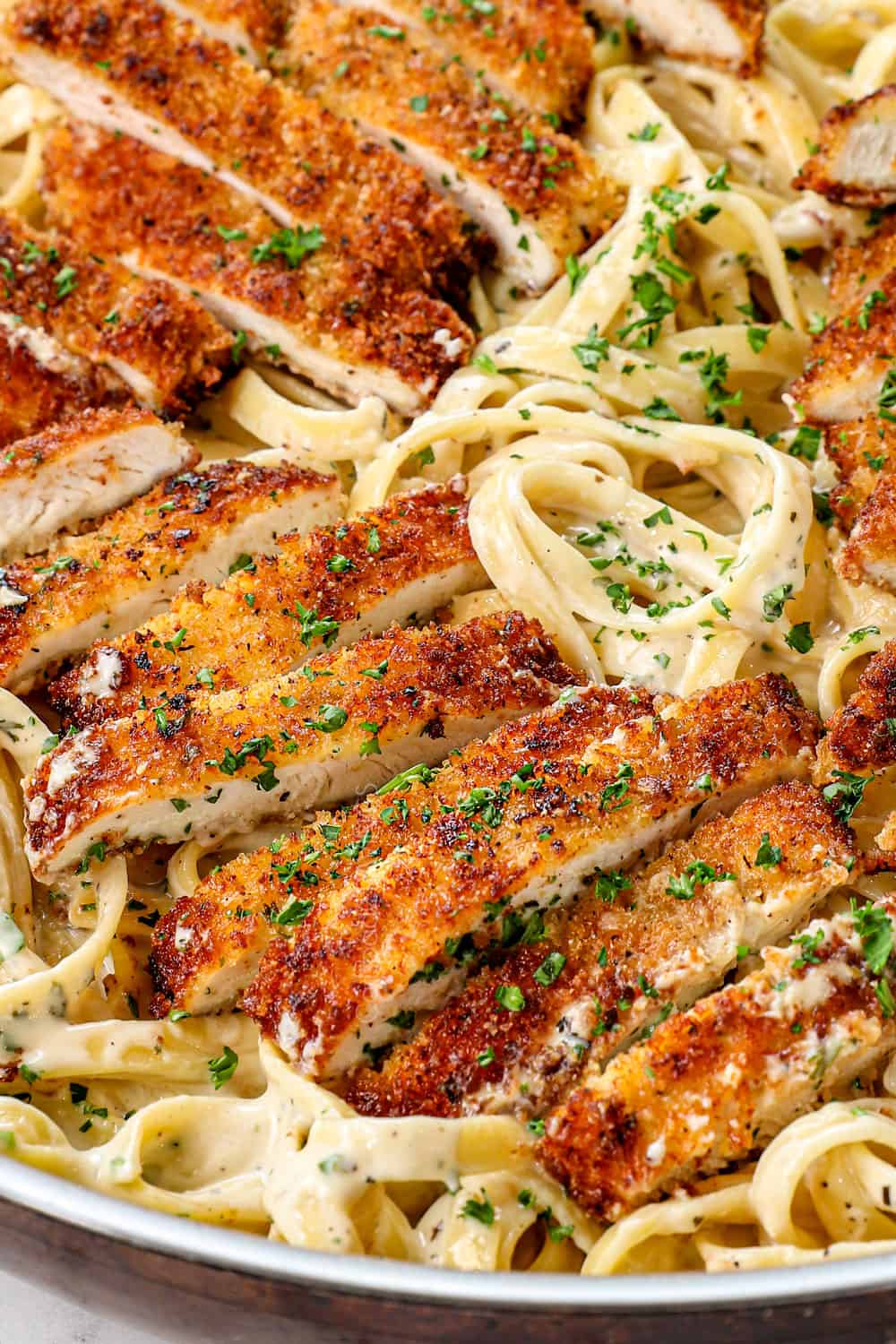 up close of chicken in chicken fettuccine alfredo showing how crispy and juicy it is