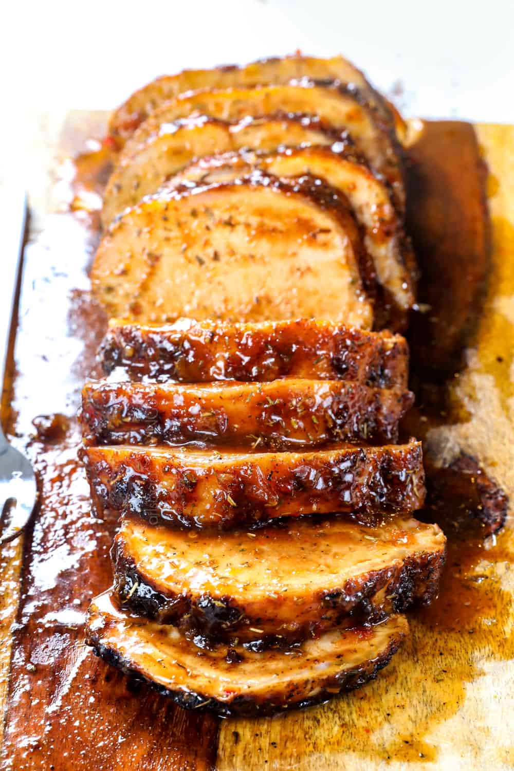 front view of roast pork loin with thick slices brushed with glaze