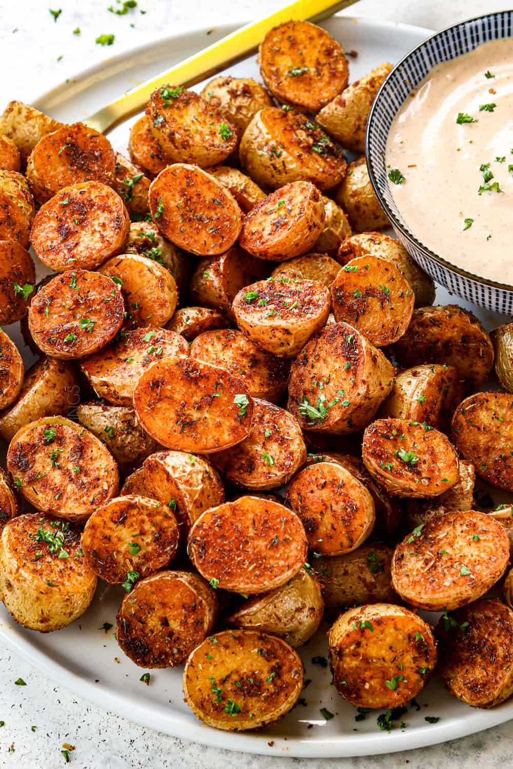 Cajun potatoes roasted in the oven on a plate with dipping sauce