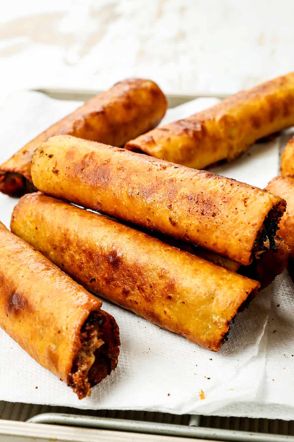 taquitos recipe stacked on paper towels showing how golden and crispy they are