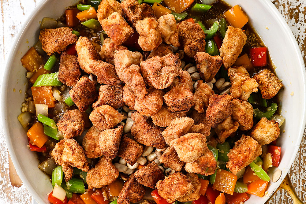 showing how to make Black Pepper Chicken by adding pepper chicken to stir fry sauce in a skillet