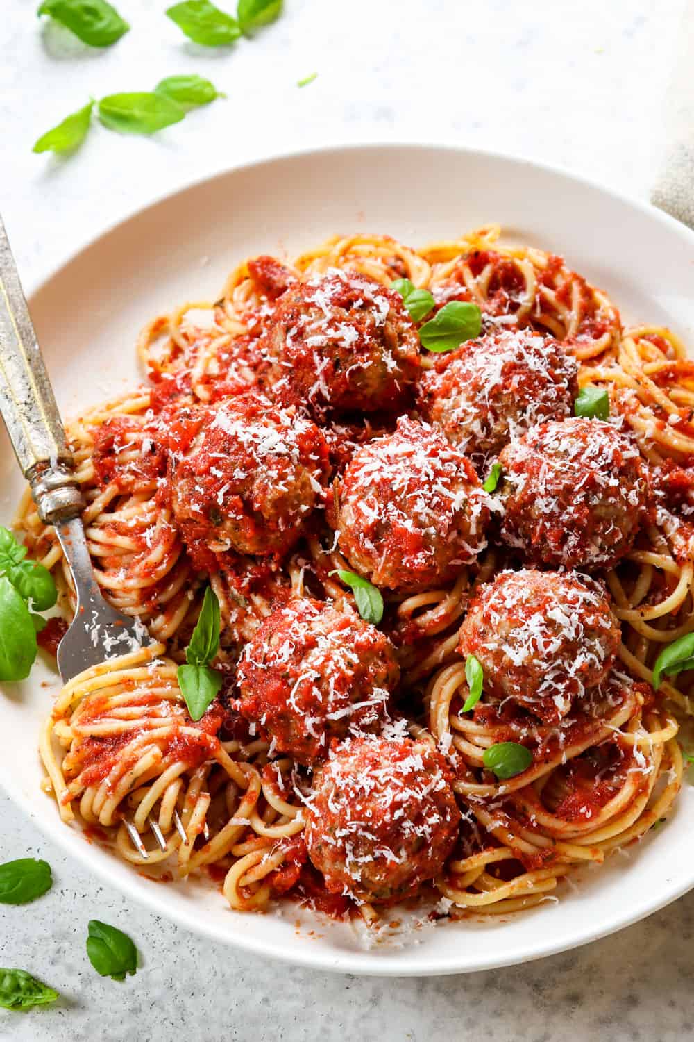 adding Italian turkey meatballs to spaghetti to serve with Parmesan