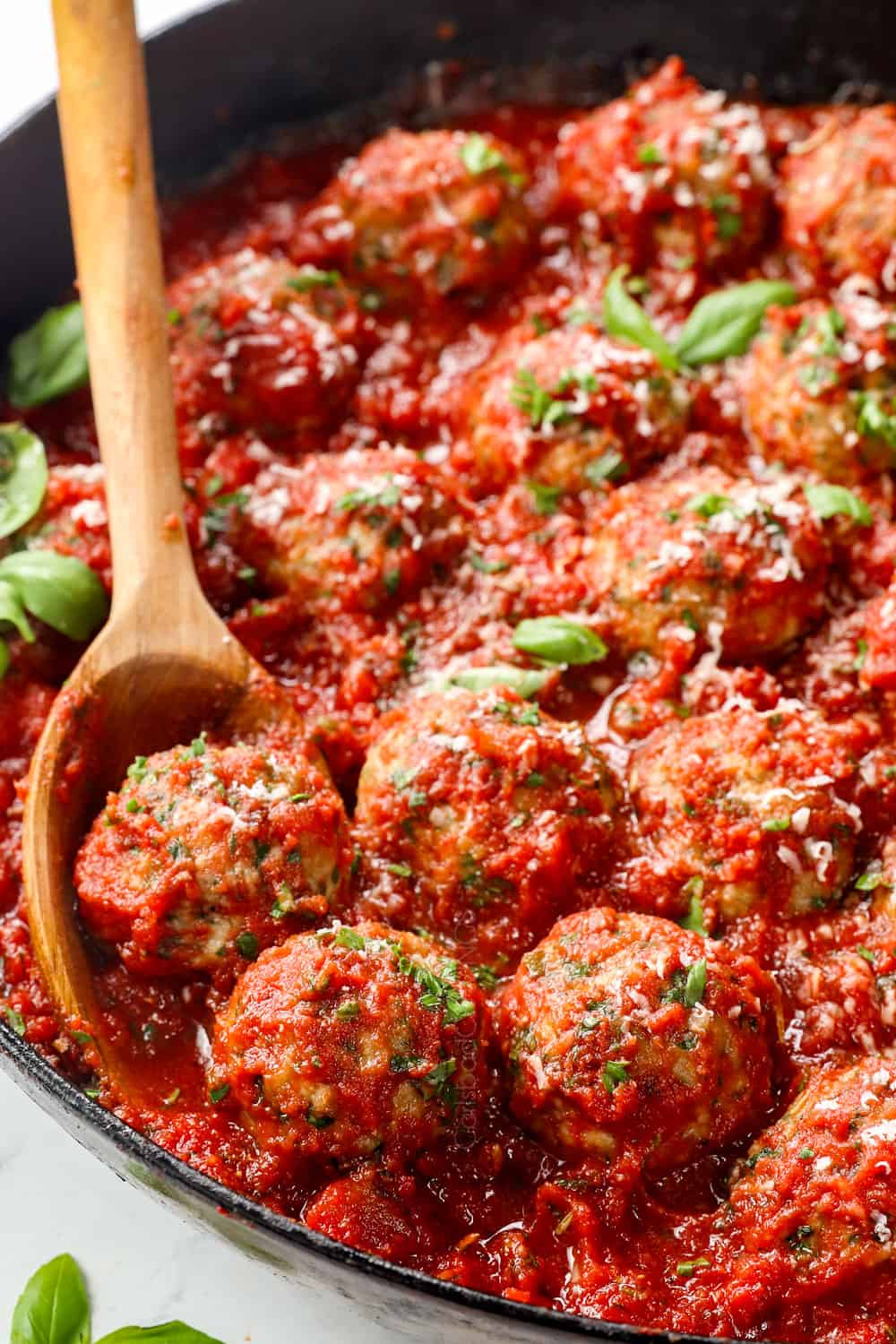 showing how to make Italian Turkey Meatballs by adding meatballs to tomato sauce