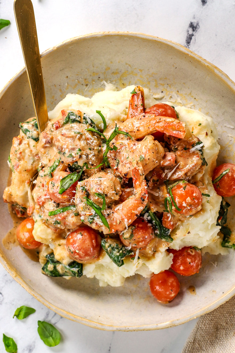 showing how to serve Tuscan shrimp by serving over a bowl of mashed potatoes