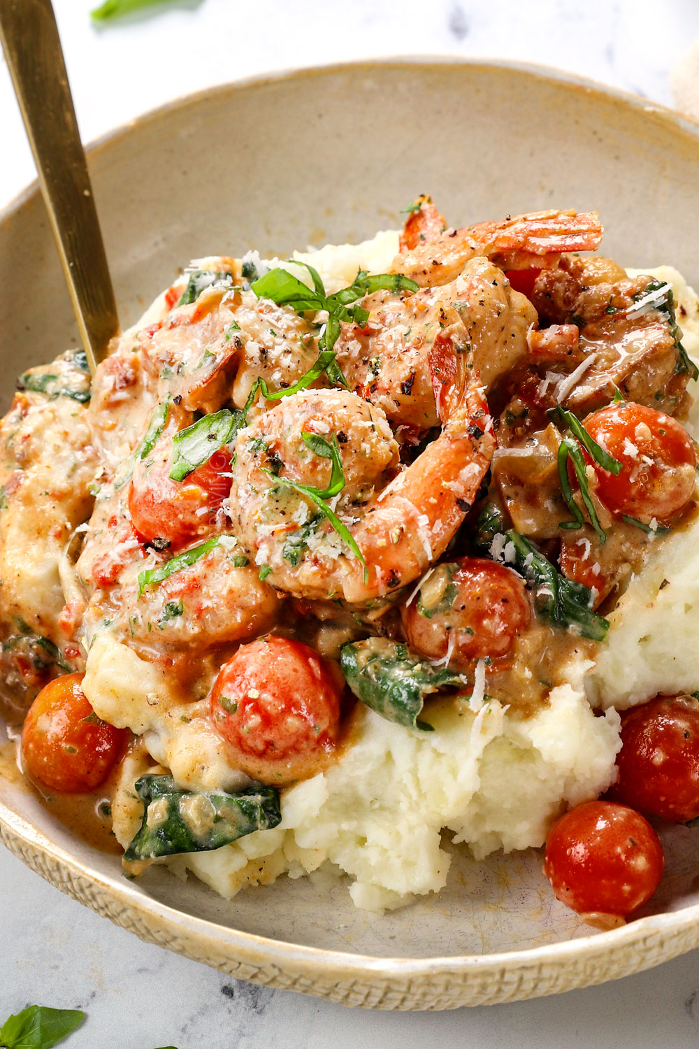 up close of serving Tuscan Shrimp over potatoes showing how creamy and saucy it is