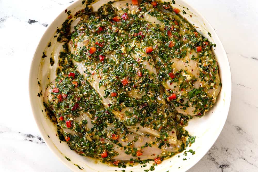 showing how to make chimichurri chicken by marinating the chicken with chimichurri