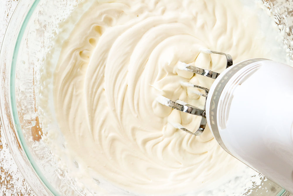 showing how to make chocolate lasagna by making homemade whipped topping with heavy cream and sugar in a mixing bowl