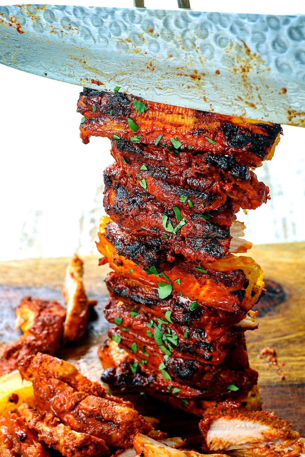 showing how to make chicken al pastor recipe by carving chicken skewers into thin slices