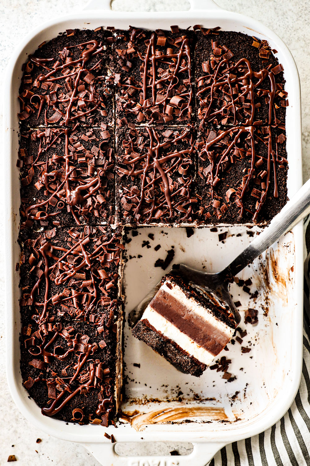 top view of chocolate lasagna showing how to add toppings of Oreo crumbs, chocolate drizzle and chocolate shavings