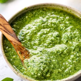 up close of pesto recipe with basil served in a green bowl