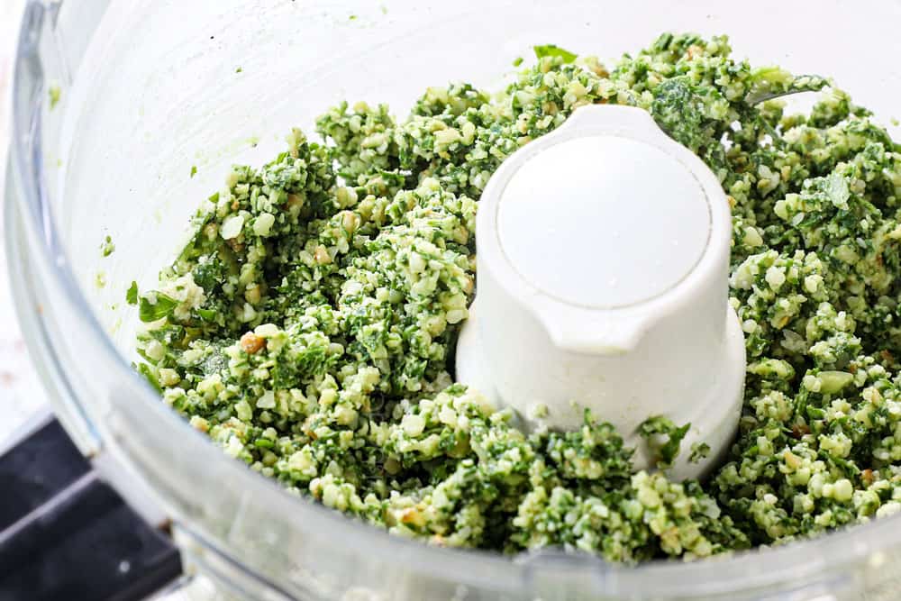 showing how to make pesto by chopping basil, Parmesan, garlic in the food processor 