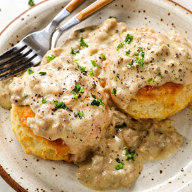 a plate of sausage gravy and biscuits showing how creamy the gravy is