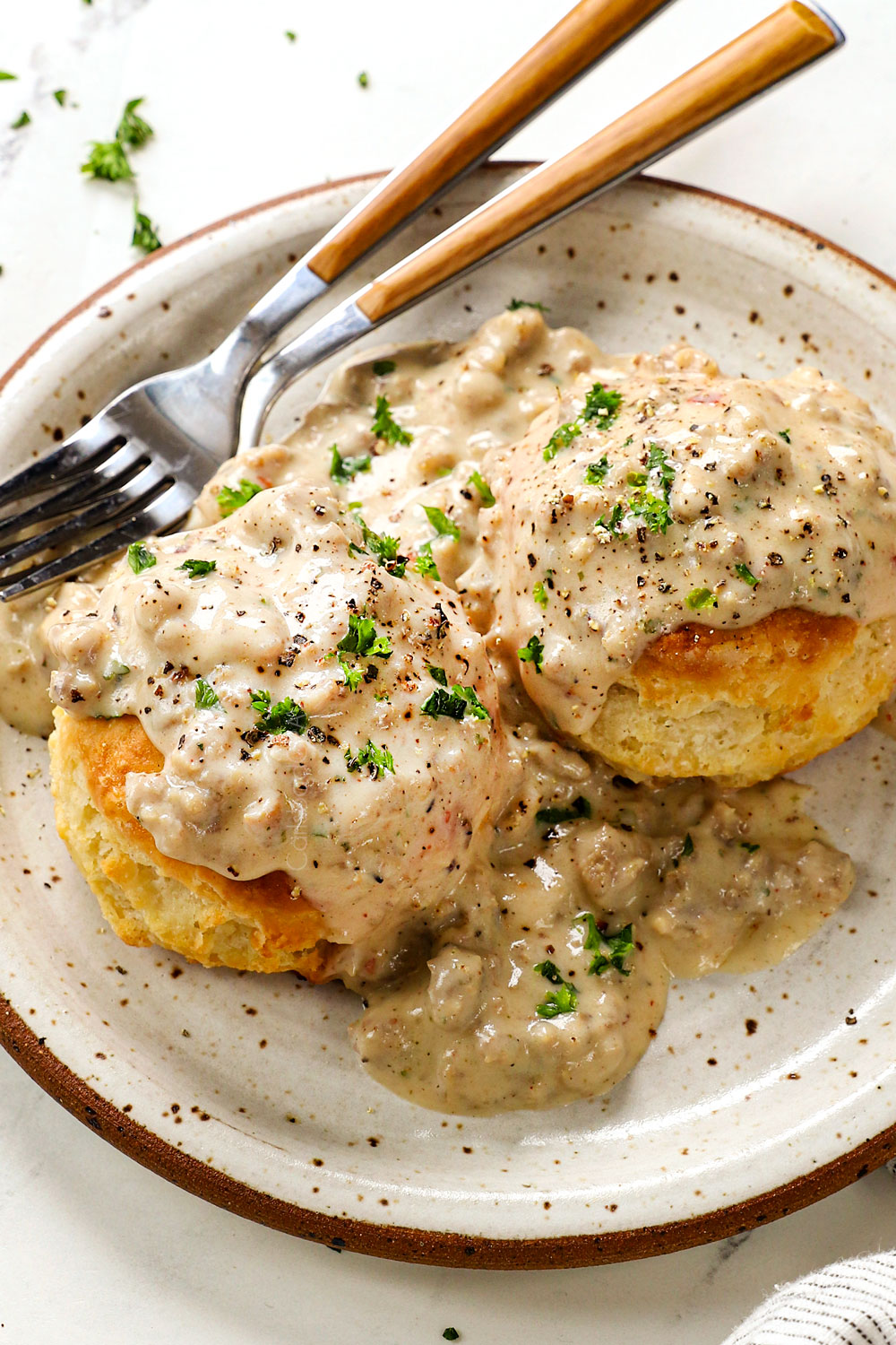 a plate of sausage gravy and biscuits showing how creamy the gravy is