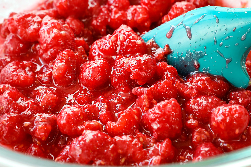 showing how to make raspberry bars with crumble topping by mixing fresh raspberries with cornstarch in a bowl to make the filling
