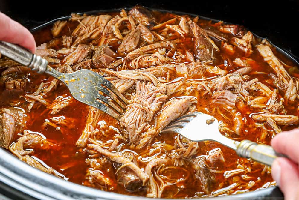 showing how to make BBQ pulled pork by shredding pork in the crockpot
