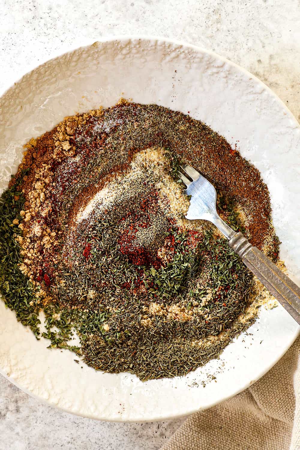 top view of showing how to make Jamaican Jerk seasoning by whisking the seasonings together in a bowl
