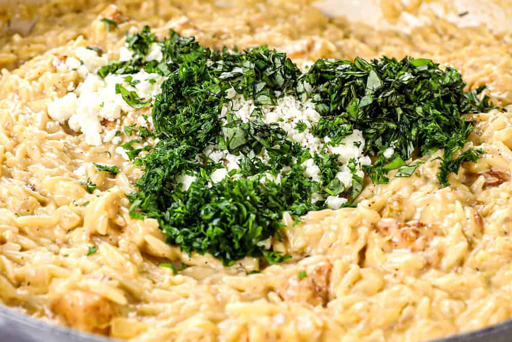 showing how to make lemon chicken orzo by adding mozzarella, feta, basil and dill to the creamy orzo with chicken