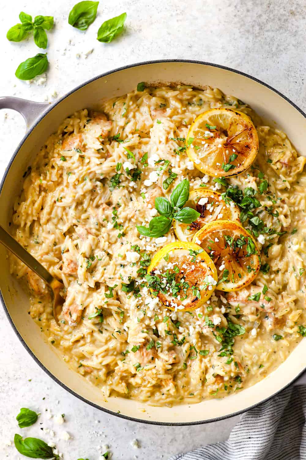 showing how to make lemon chicken orzo by simmering in one pot then garnishing with feta