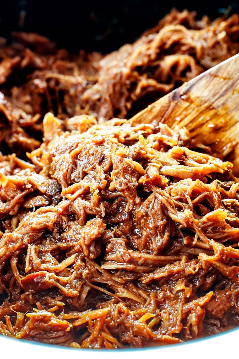 showing how to make BBQ pulled pork sandwiches by combining pulled pork with homemade barbecue sauce
