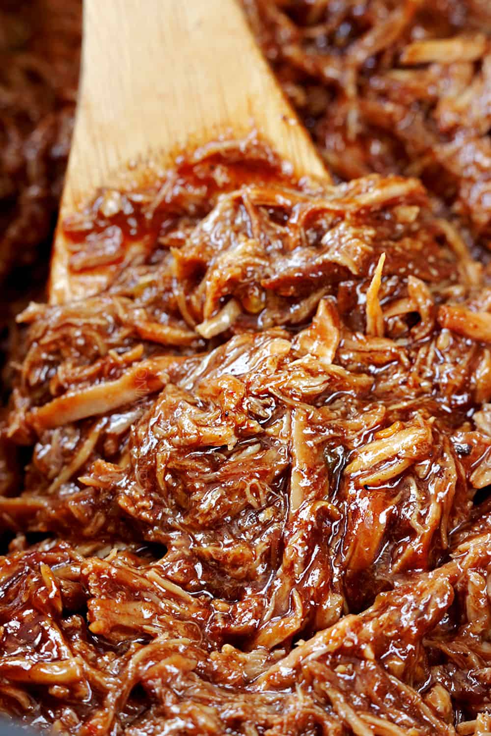 up close of making bbq pork for pulled pork sandwiches showing how saucy it is
