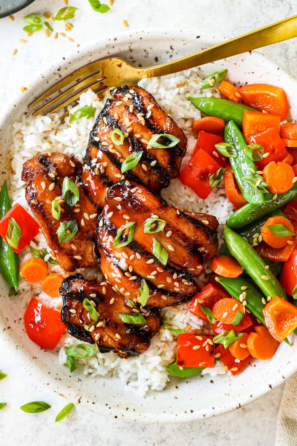 showing how to serve marinated grilled boneless chicken thighs with rice and vegetables