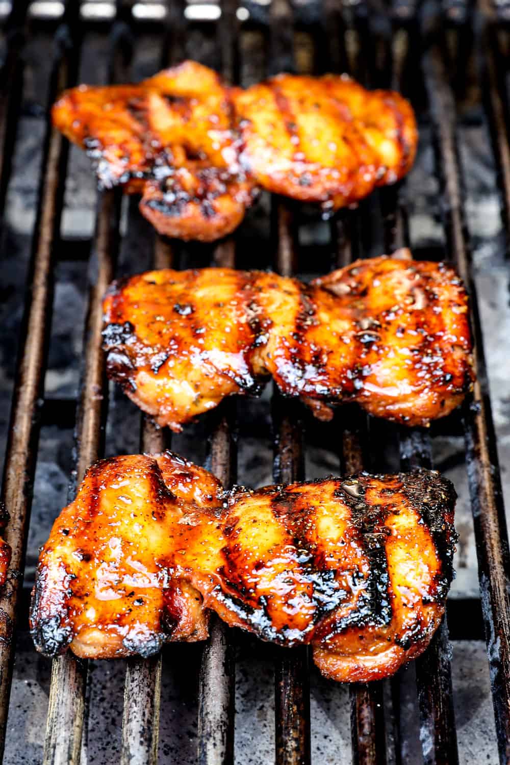 showing how to make grilled chicken thighs by grilling on the grill until seared and golden