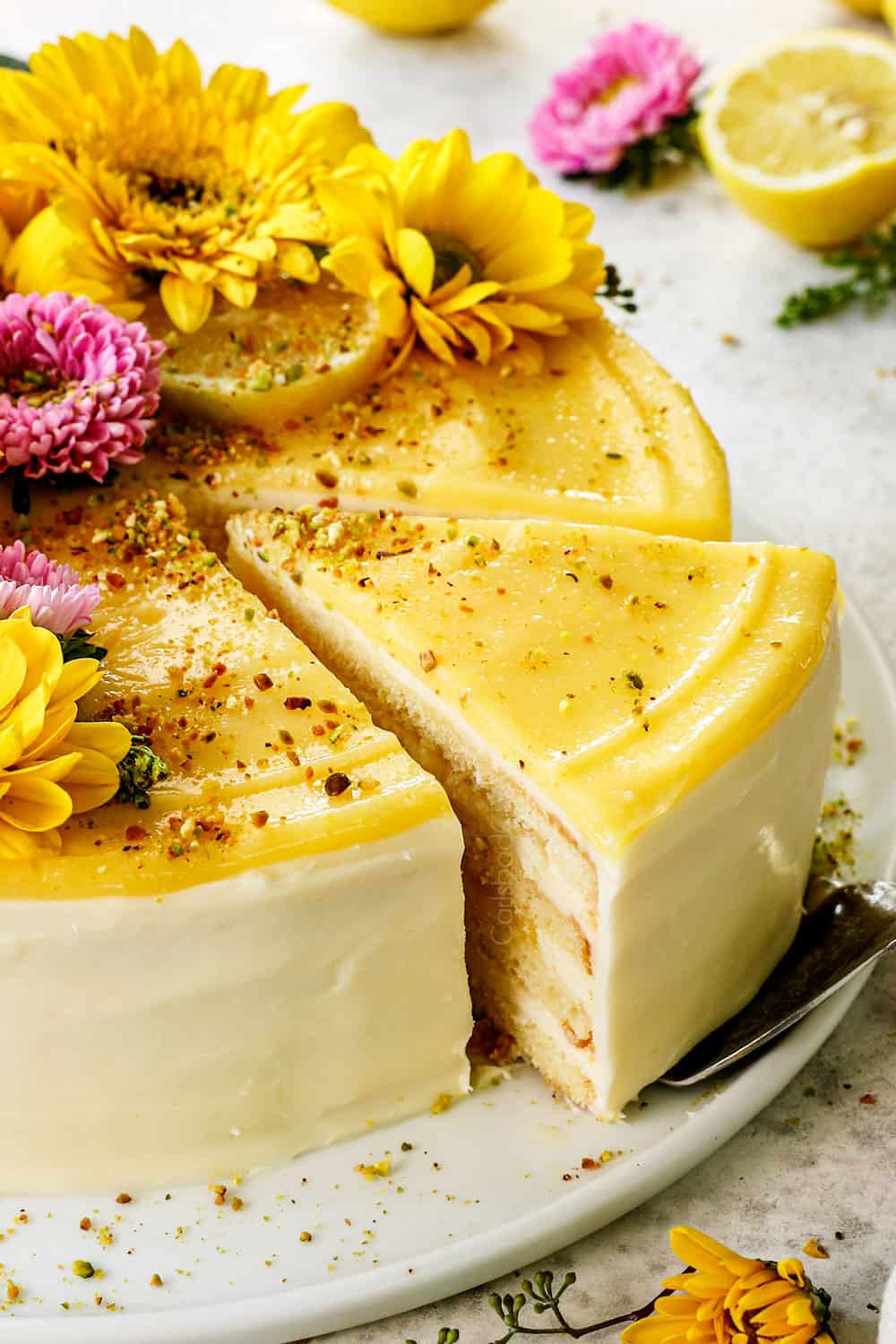 removing a slice of best lemon cake showing the layers of moist cake and lemon curd