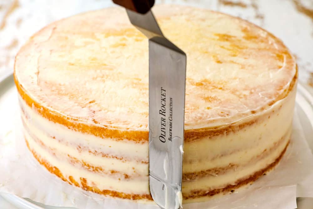 showing how to make lemon cake by applying a crumb coat of frosting