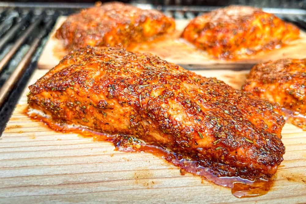 showing how to make cedar plank salmon recipe by grilling salmon on cedar planks