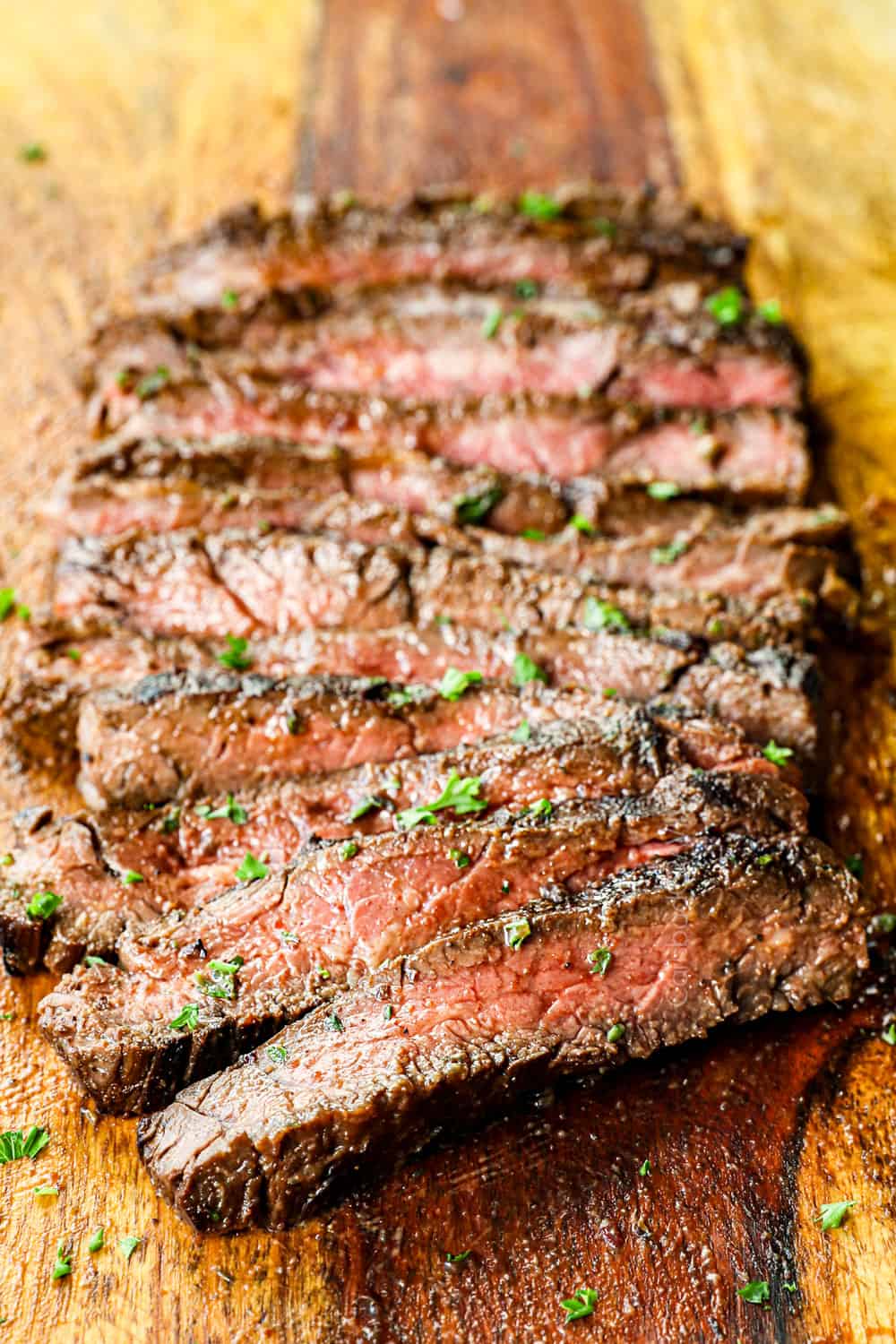 skirt steak recipe marinated and grilled, then sliced across the grain on a cutting board