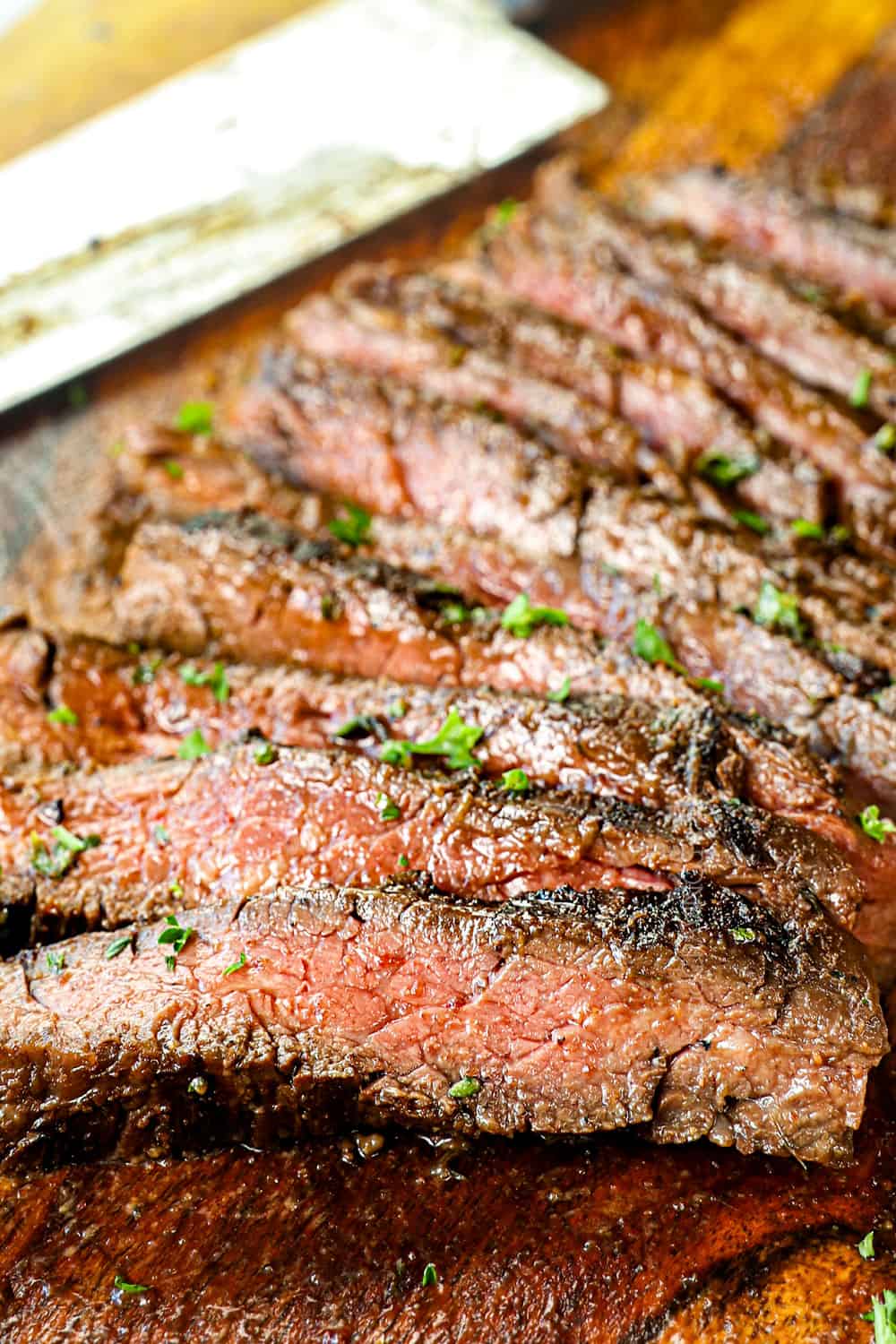 marinated skirt steak sliced on a cutting board showing how juicy it is