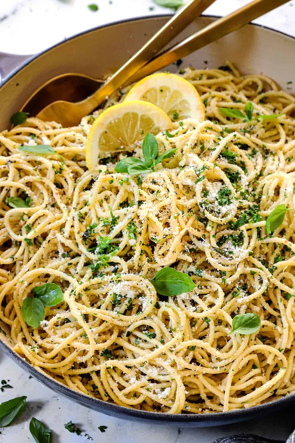 lemon pasta recipe (pasta al limone) in a pot garnished with cheese, basil and Parmesan