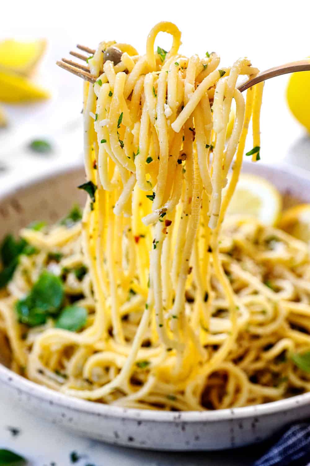 serving lemon pasta recipe (pasta al limone) by picking up lemon pasta with two forks