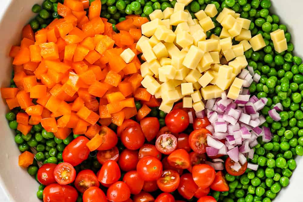 showing how to make pea salad by adding peas, cheese, bacon, onions to a bowl