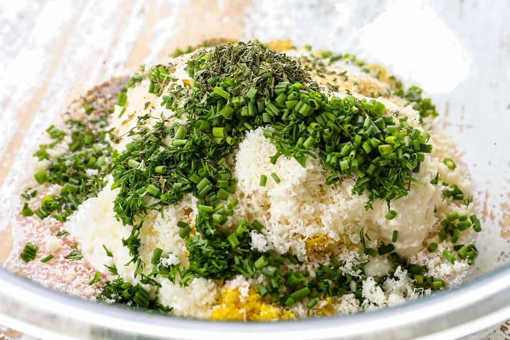 showing how to make pea salad recipe by making the dressing with mayonnaise, sour cream, Parmesan, dill, chives and parsley