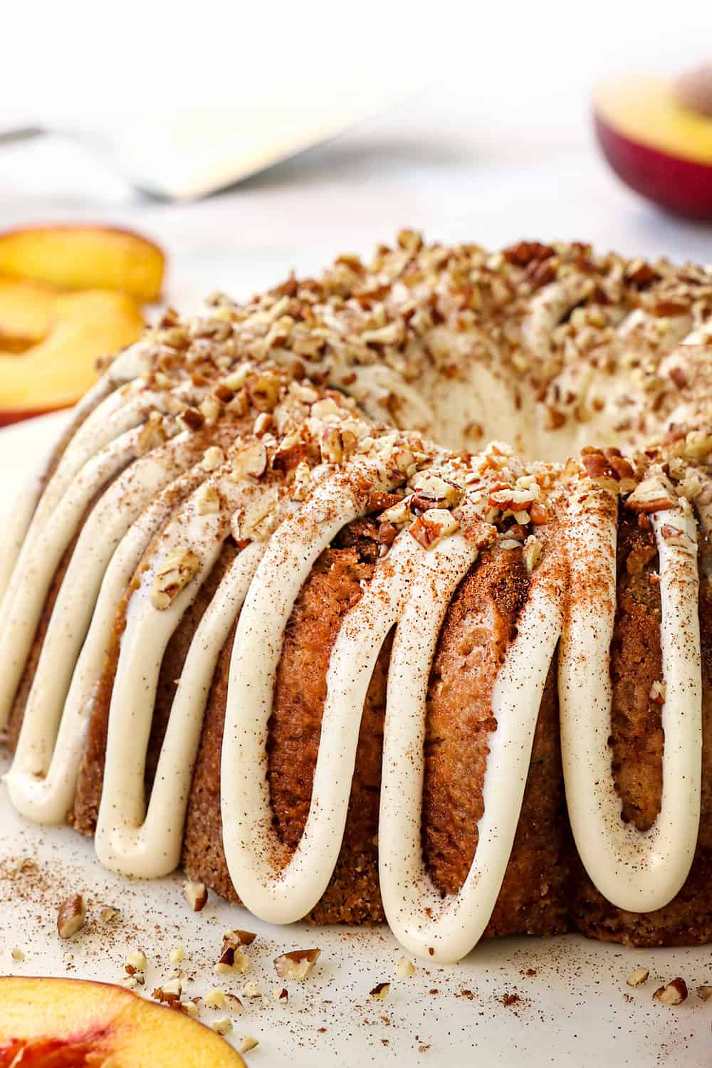 up close of peach cake recipe with fresh peaches garnished with pecans
