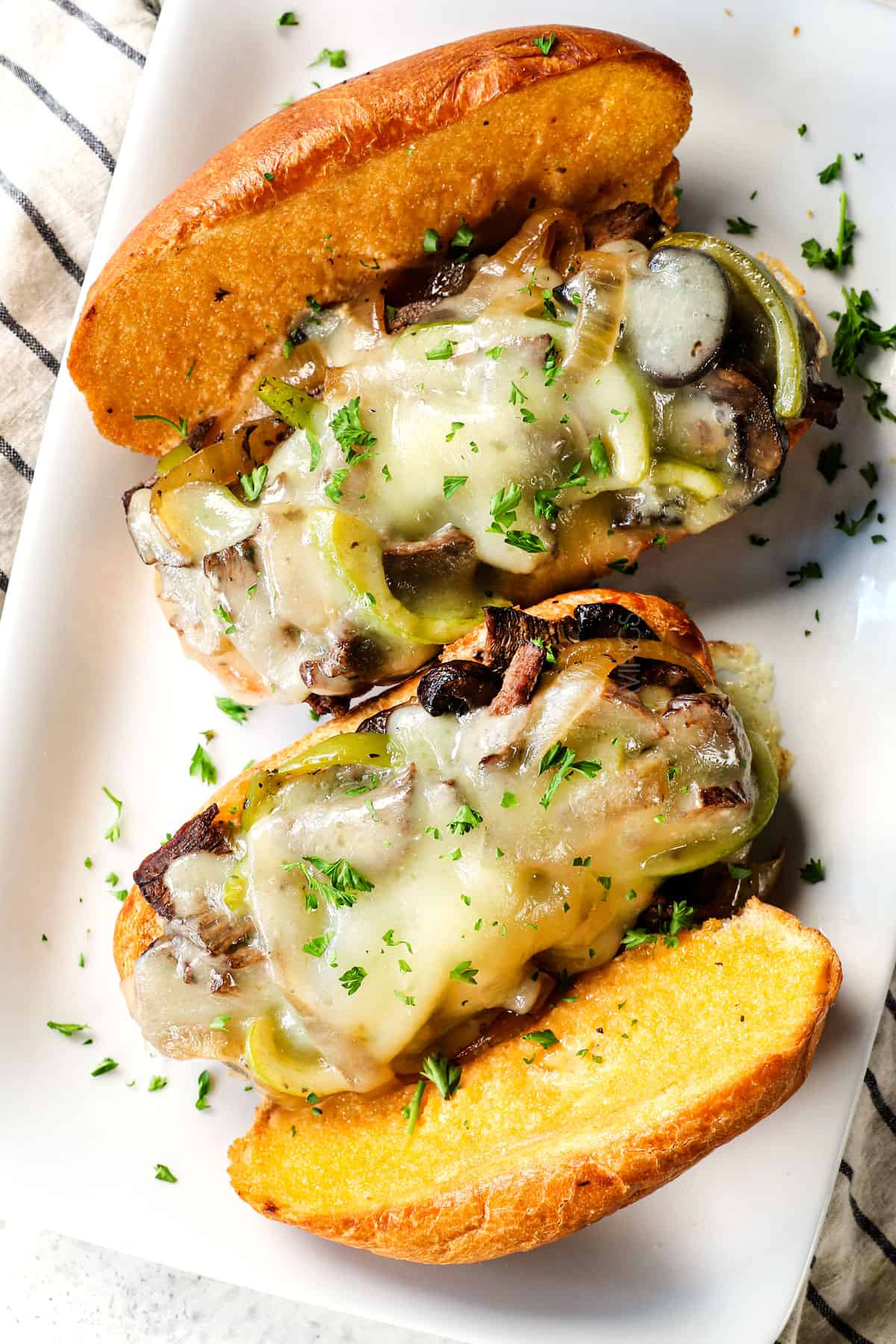 top view of authentic Crockpot Philly Cheesesteak recipe on hoagie rolls with provolone cheese