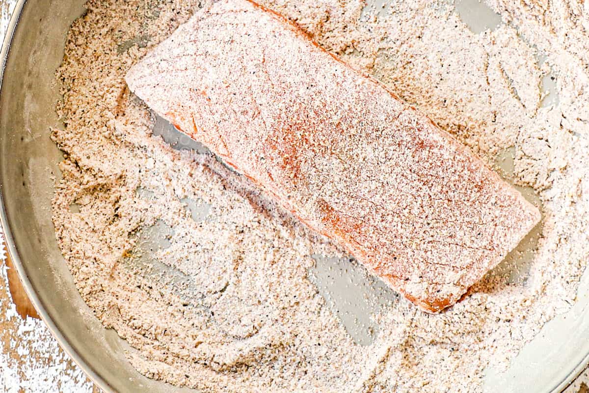 showing how to serve pan seared firecracker salmon by dredging salmon in flour and spices before pan searing