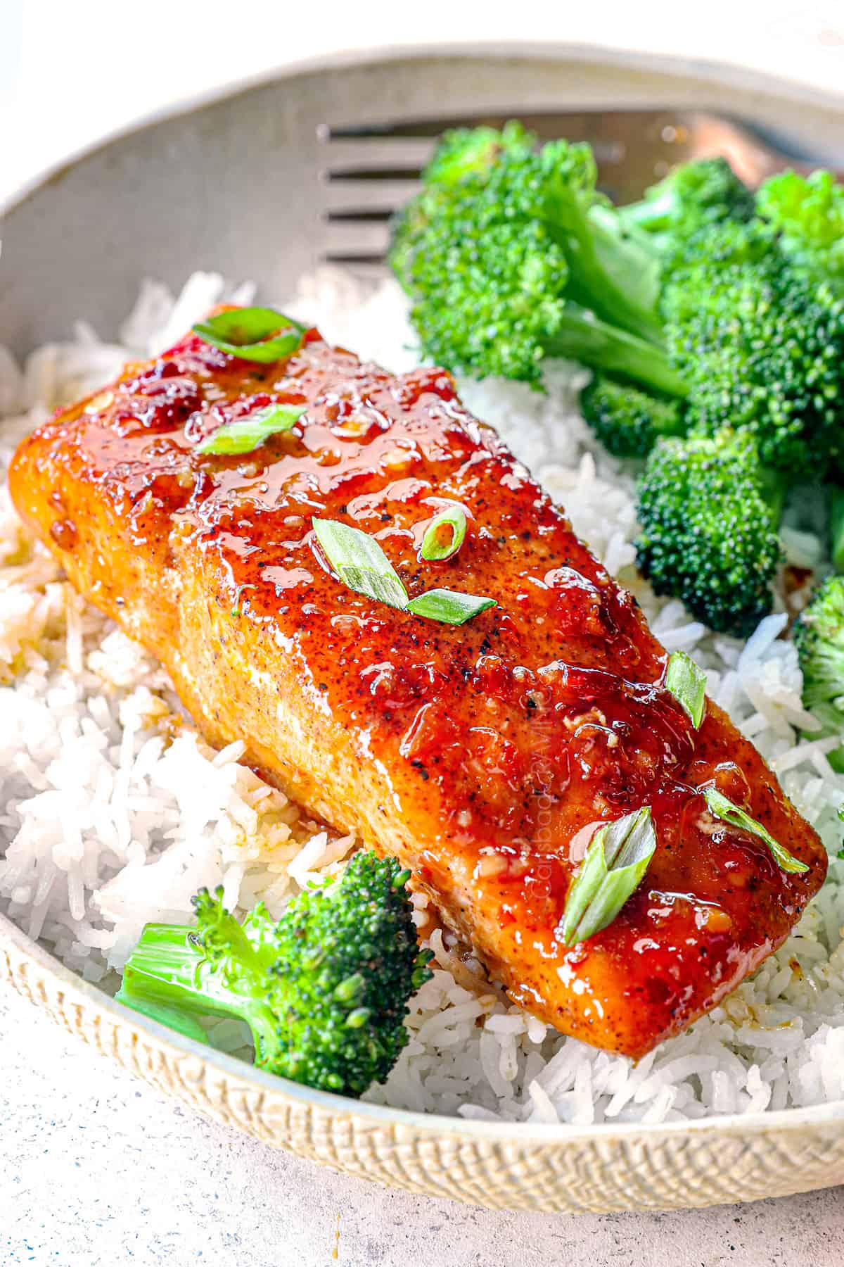 showing how to serve sweet and spicy firecracker salmon by serving over rice