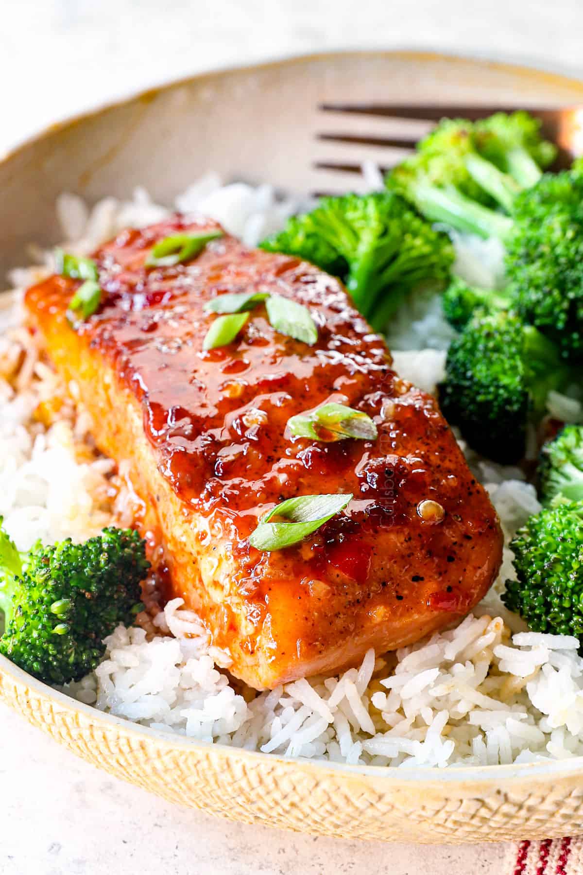 showing how to serve sweet and spicy firecracker salmon by serving over rice