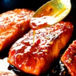 showing how to make firecracker salmon by pouring the sauce over top the pan seared salmon