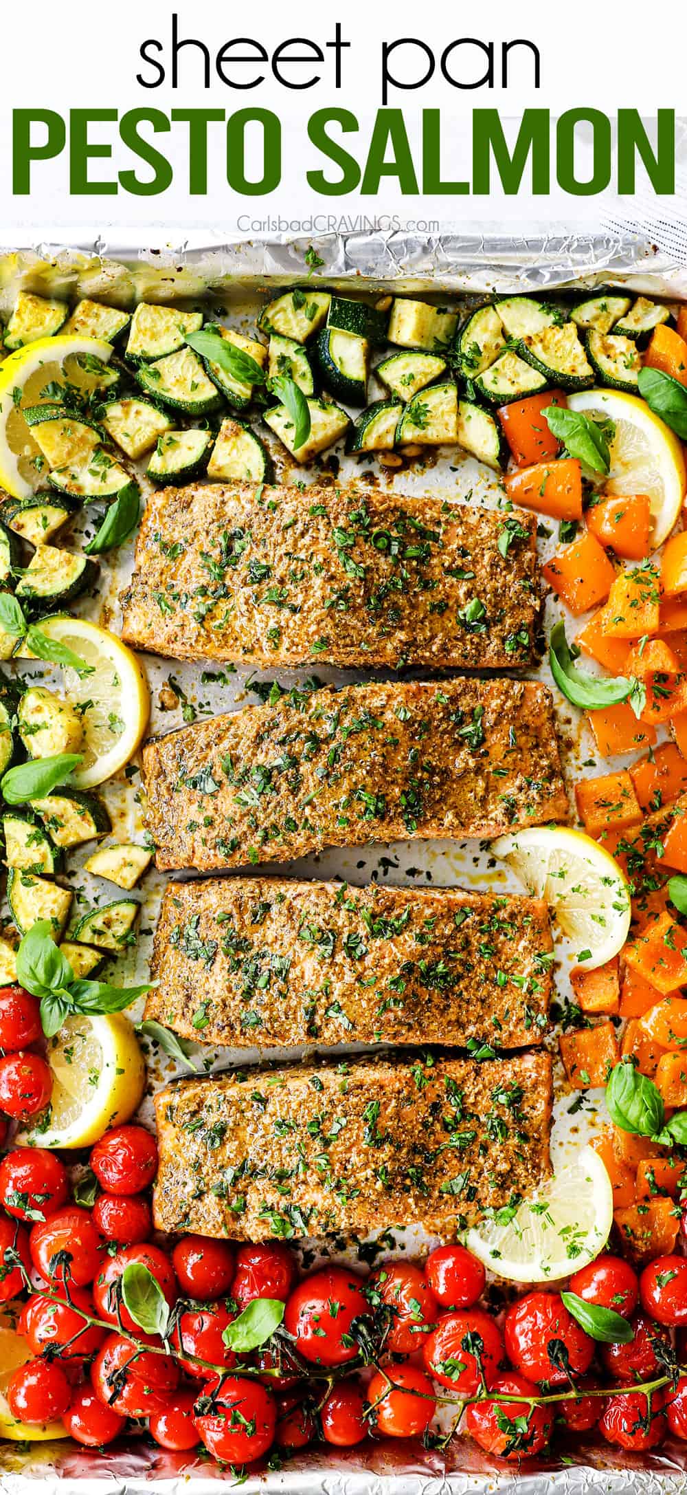 showing how to make baked pesto salmon recipe by adding salmon with pesto, tomatoes, zucchini and bell peppers on a baking sheet