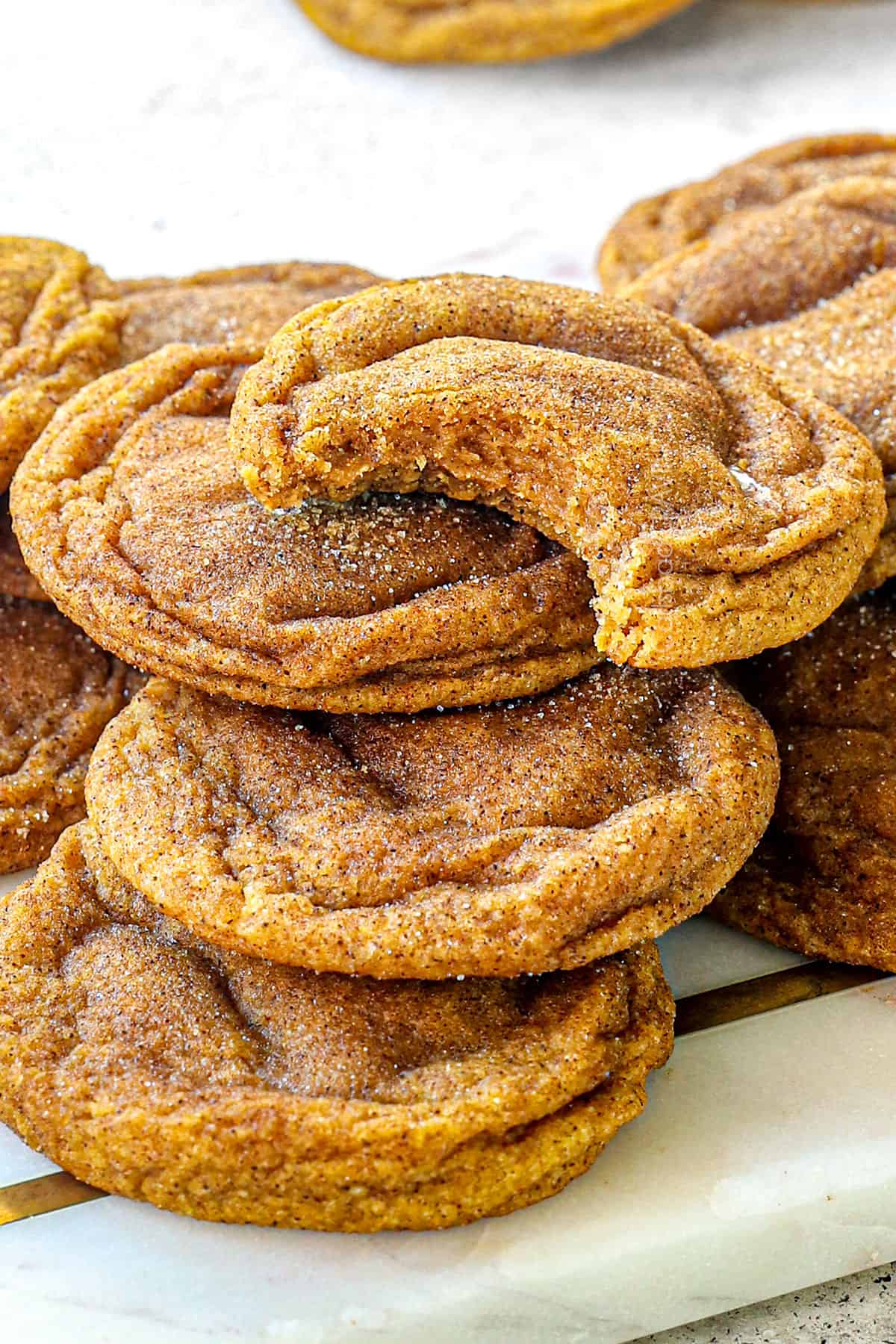 snickerdoodle pumpkin cookies with a bite taken out showing how fluffy, thick and chewy they are