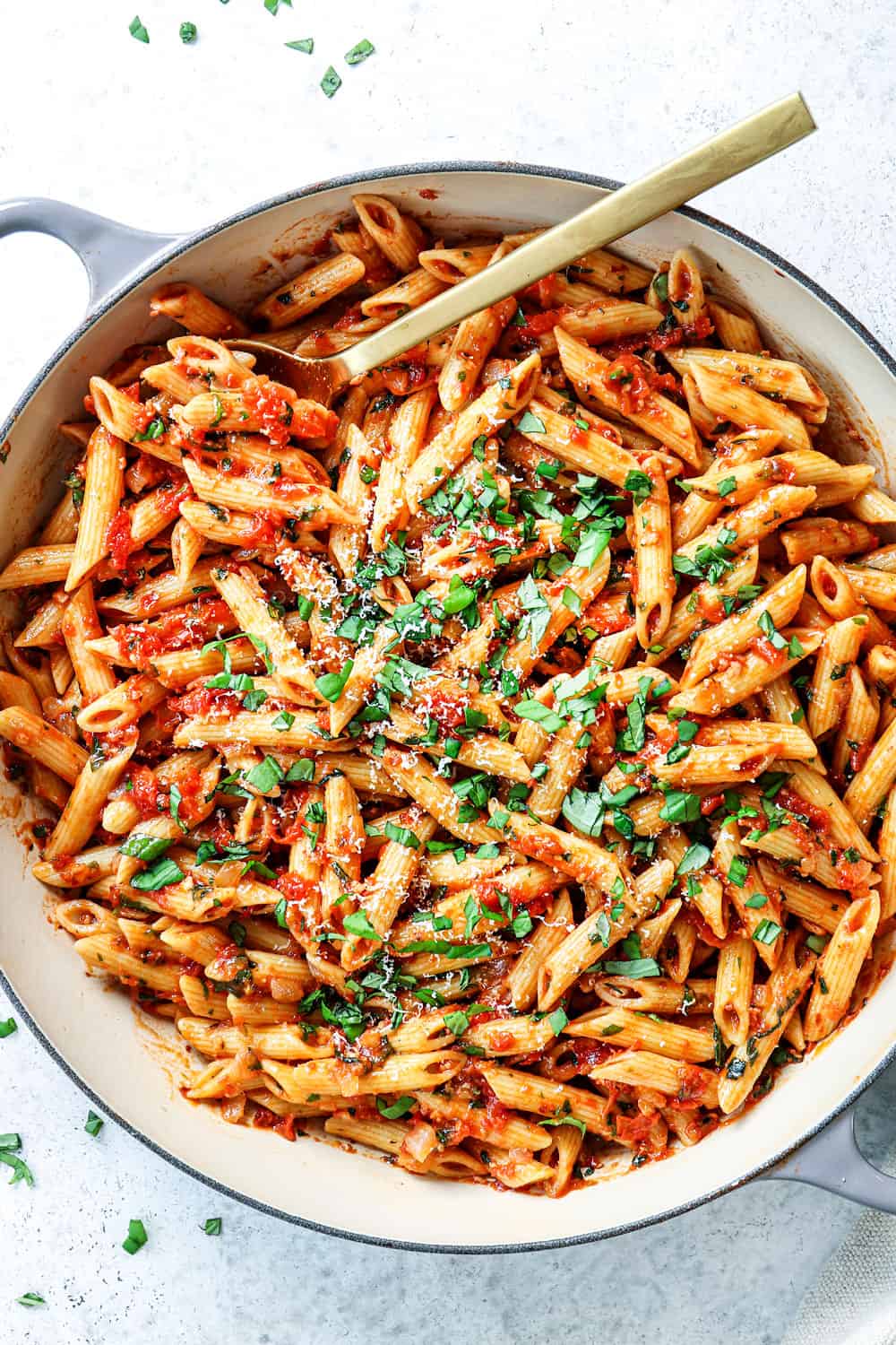 top view of Arrabiata sauce tossed with penne, basil  in a pan