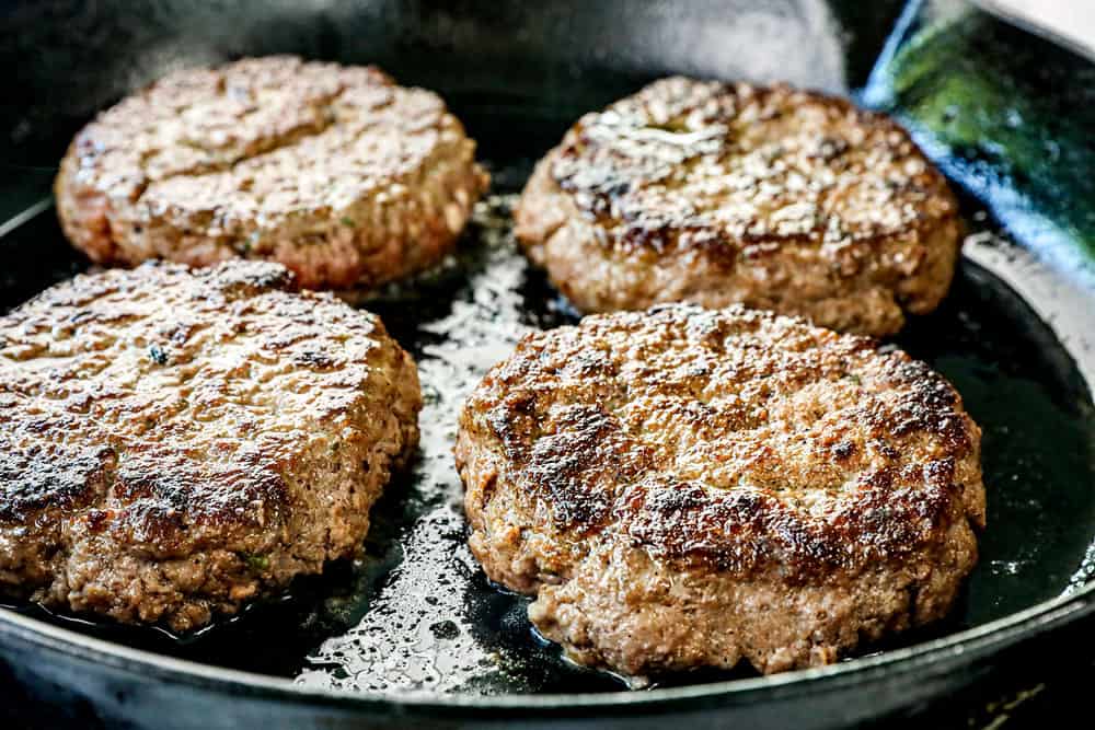 showing how to make loco moco recipe by cooking burgers in a skillet