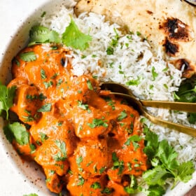 showing how to serve chicken tikka masala recipe by adding to a bowl with basmati rice with naan