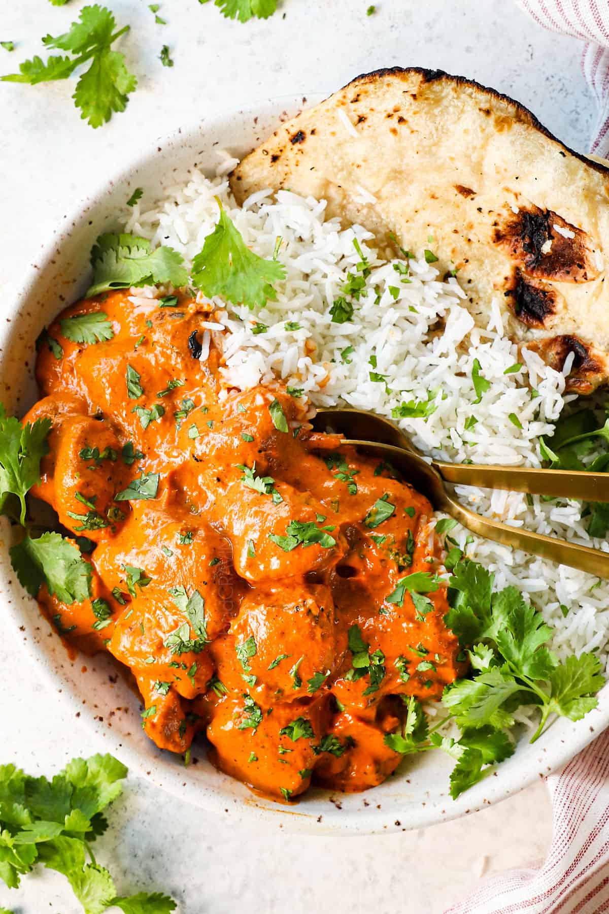 showing how to serve chicken tikka masala recipe by adding to a bowl with basmati rice with naan