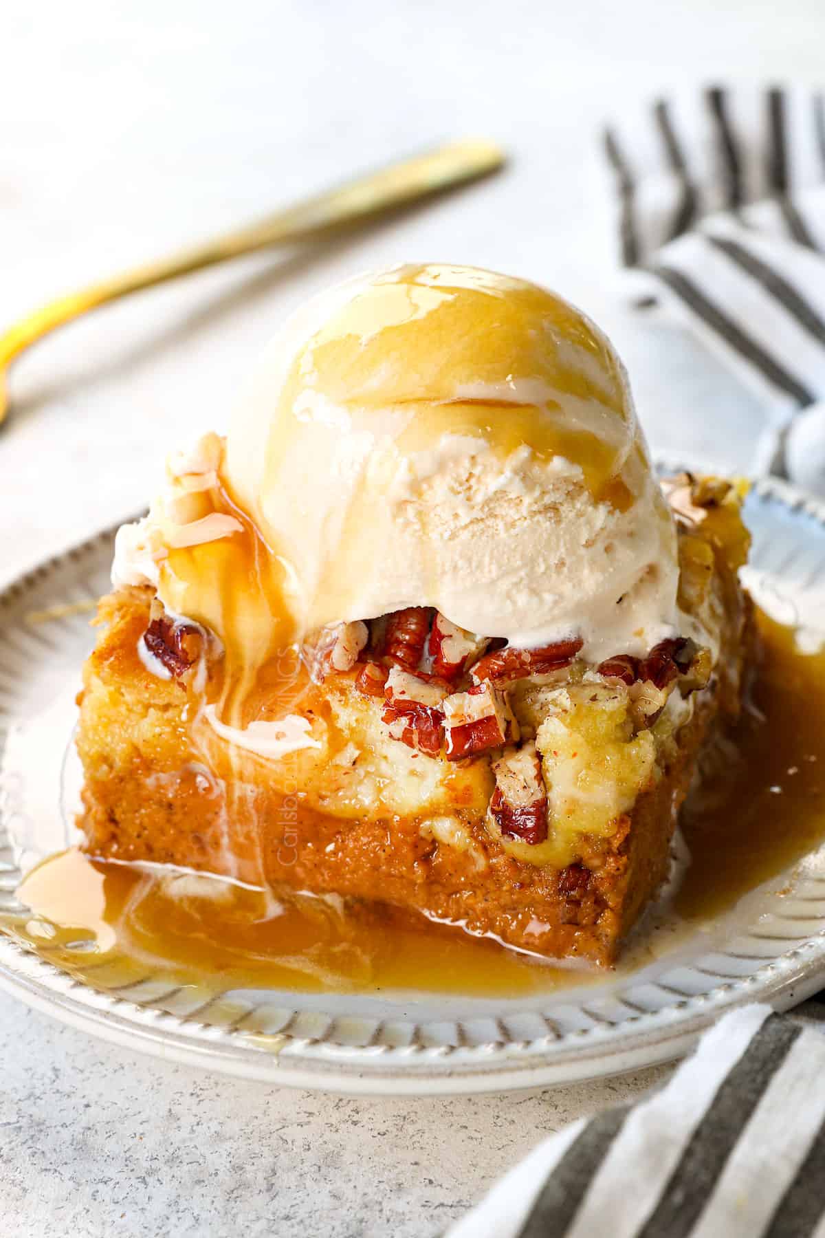 showing how to serve pumpkin dump cake by adding to a plate with whipped cream 