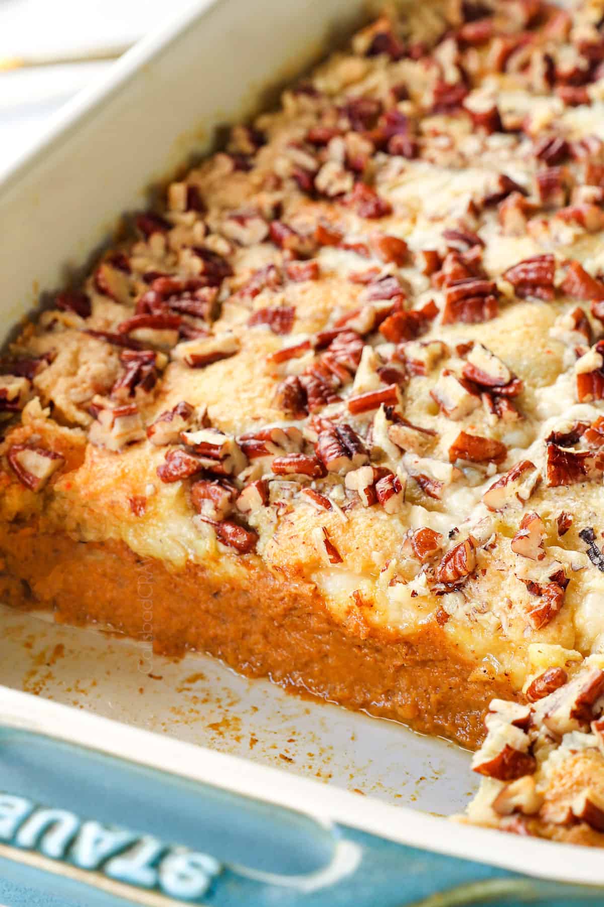 pumpkin dump cake recipe in a 9x13 pan showing the pumpkin filling and cake mix topping