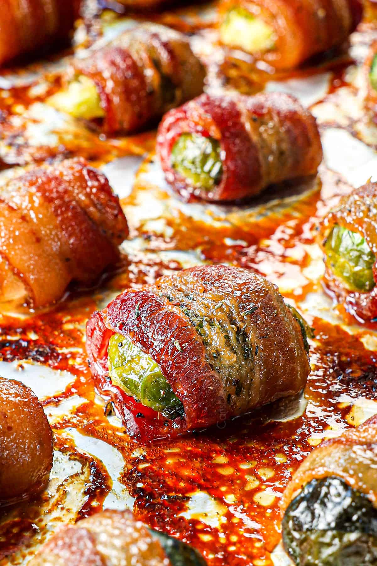 up close of roasting Bacon Wrapped Brussels Sprouts on a baking sheet